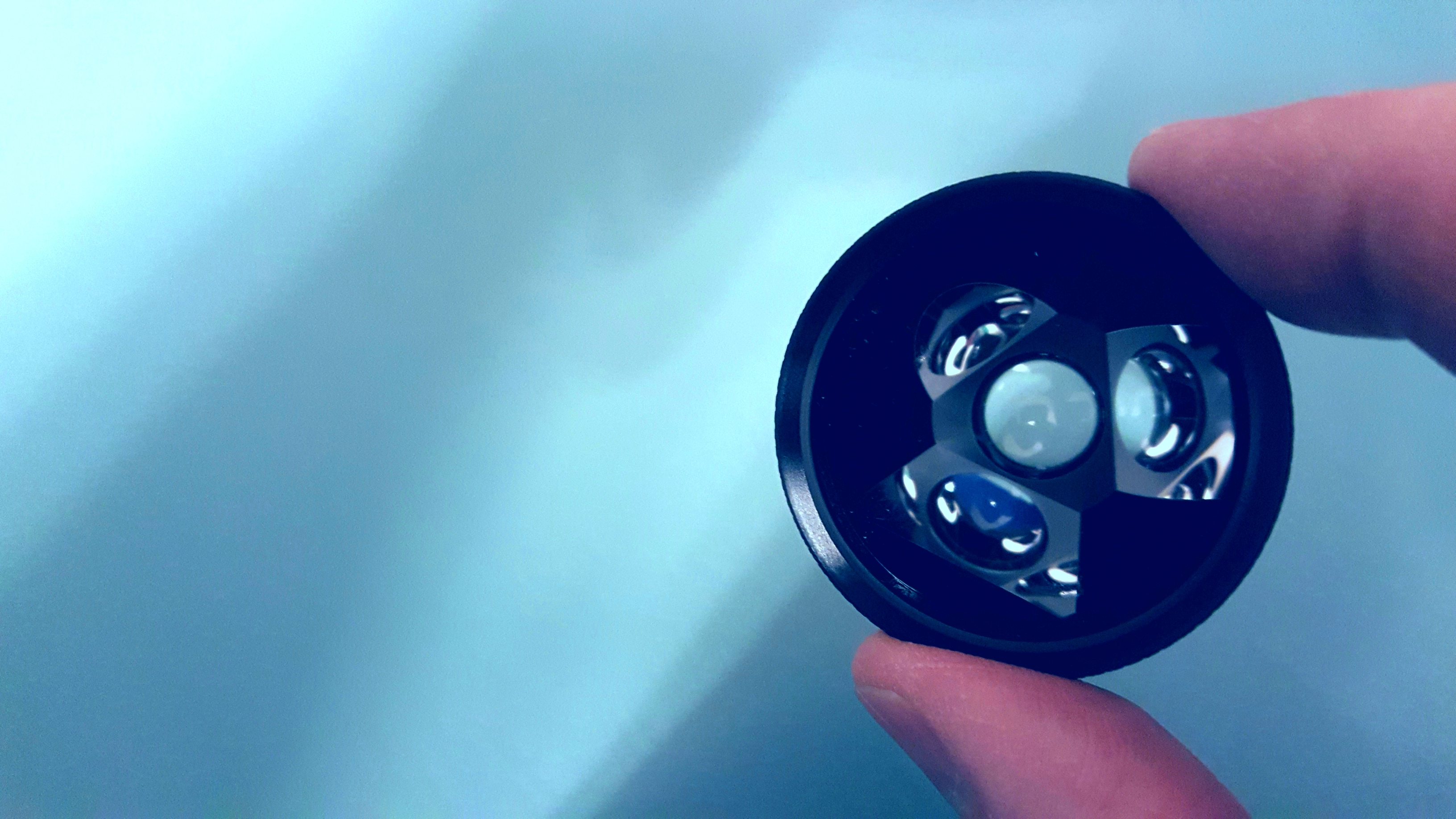 Person holding up a gonioscopy lens